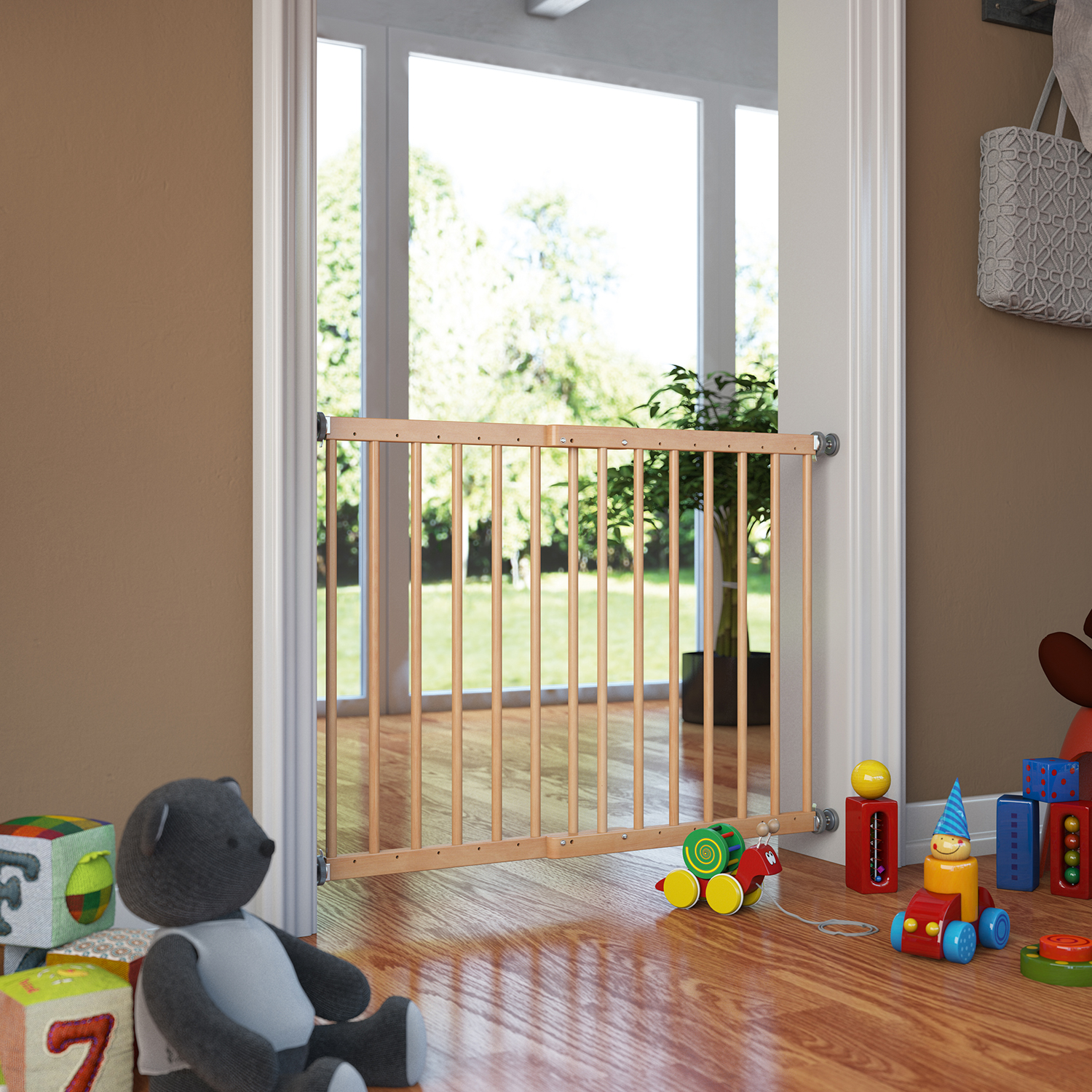 Barrera de seguridad de madera instalada en un marco de puerta, en una habitación con juguetes infantiles en el suelo y vista a un jardín al fondo.